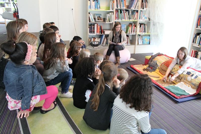 enfants écoutant et regardant l'histoire du raconte-tapis
