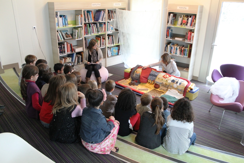 enfants écoutant et rgardant l'histoire du raconte-tapis